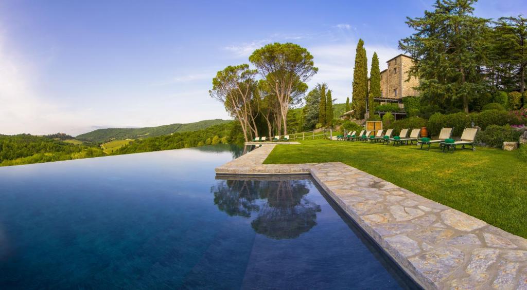 - une piscine entourée d'une pelouse avec des chaises dans l'établissement Castello di Spaltenna Exclusive Resort & Spa, à Gaiole in Chianti