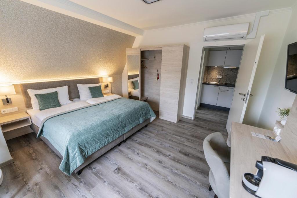 1 dormitorio con 1 cama grande y cocina en Hökis-Zimmervermietung 8 mit Küchenzeile, en Brande-Hörnerkirchen