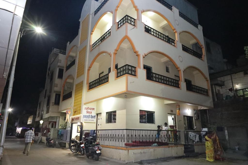 um edifício com pessoas do lado de fora à noite em Hotel laxminarayan em Shirdi