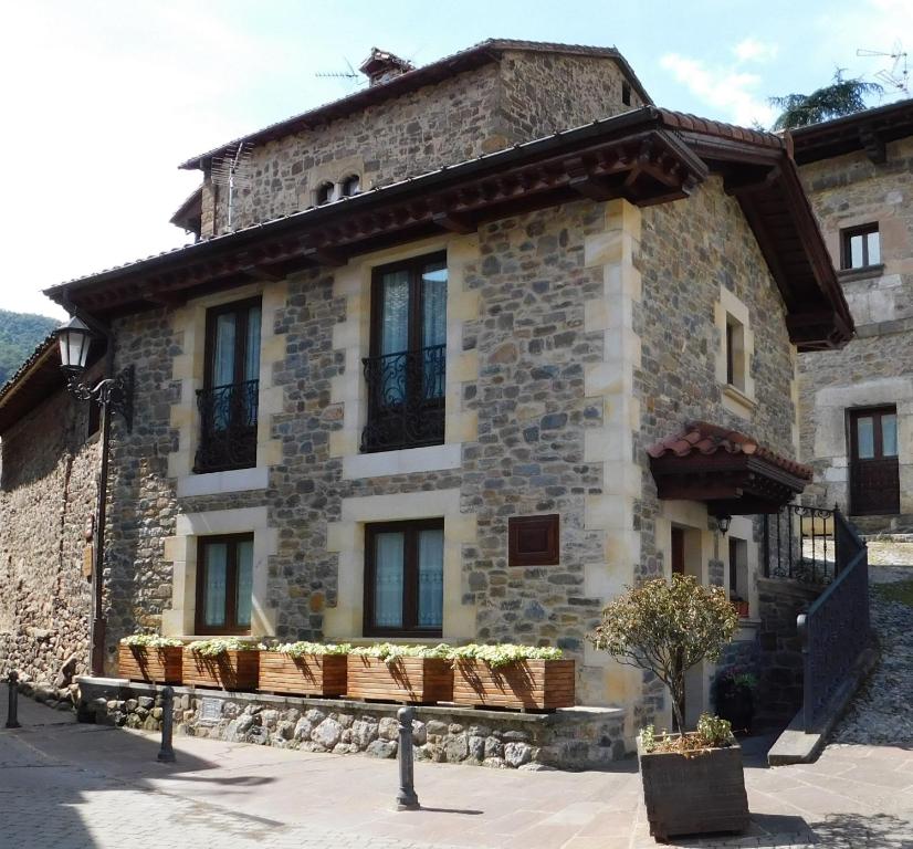 un ancien bâtiment en pierre avec des plantes devant lui dans l'établissement Casa del Horno, à Potes