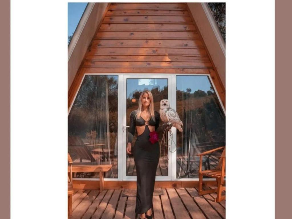 a woman in a black dress holding an owl at FALCOARIA de Santa Efigenia in Setúbal