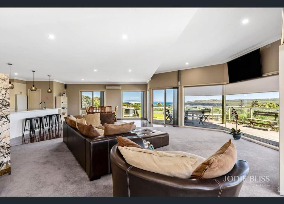 ein Wohnzimmer mit Sofas und eine Küche mit Aussicht in der Unterkunft Freestanding house with ocean view in Port Campbell