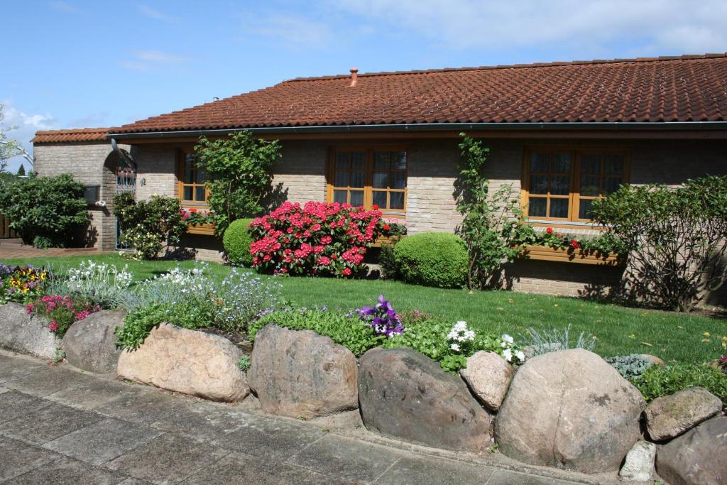 um jardim em frente a uma casa com flores em Ferienhaus Weingarten em Bad Fallingbostel