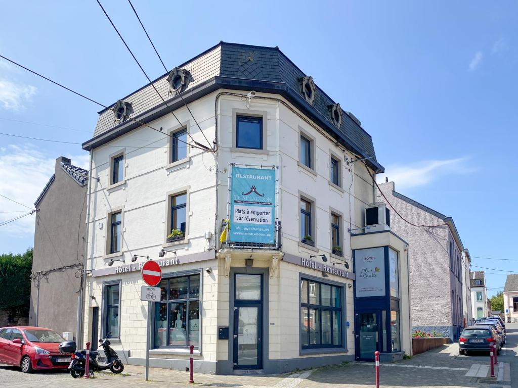 een wit gebouw op de hoek van een straat bij Hotel A Fleur de Couette in Auvelais