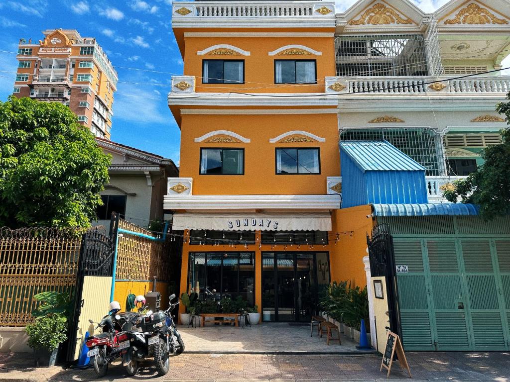 una moto parcheggiata di fronte a un edificio di Sundays Café & Hotel a Phnom Penh