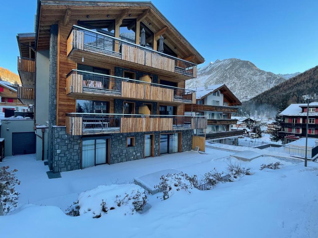 un edificio en la nieve con terrenos cubiertos de nieve en Berghof, en Saas-Fee