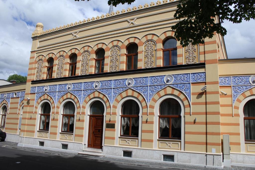 um edifício antigo com azul e amarelo em İsa Begov Hamam Hotel em Saraievo