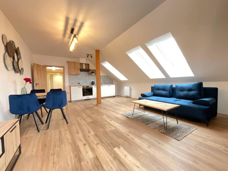 a living room with a blue couch and a table at Apartmán č.3 v bankovním domě in Kutná Hora