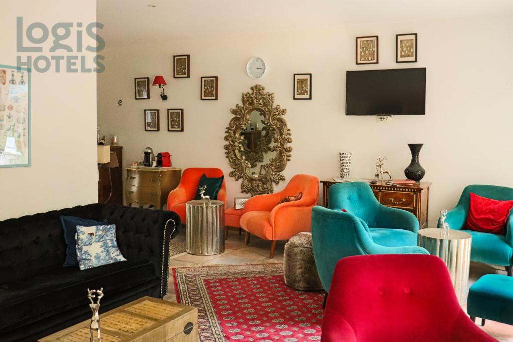 a living room with colorful chairs and a tv at A La Villa Boucicaut in Chalon-sur-Saône