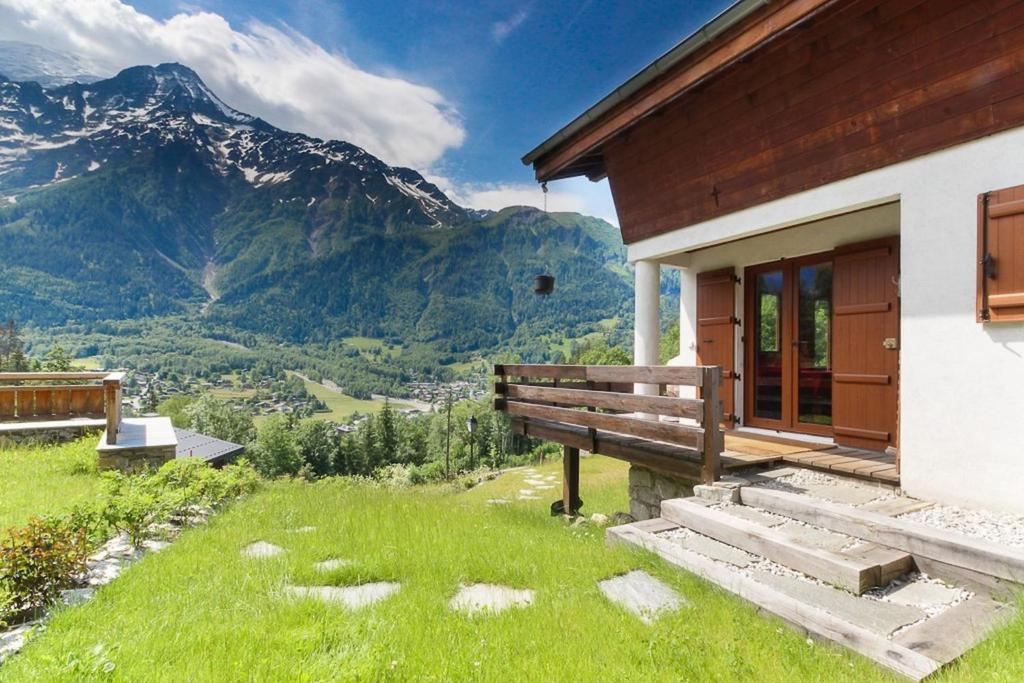 The Historic Chalet Les Allognes Mont-Blanc views في لي أوش: مبنى مع مقاعد وإطلالة على جبل