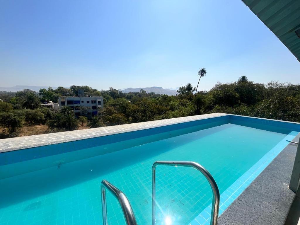 - une piscine bleue avec vue sur le désert dans l'établissement Airspace villa, à Igatpuri