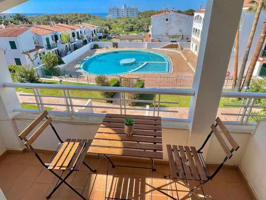 balkon z 2 krzesłami i basenem w obiekcie Mitjaneta Apartamento con piscina w mieście Cala en Blanes