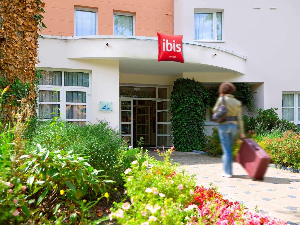 een persoon die voor een gebouw loopt met een "ups sign" bij ibis Nancy-Brabois in Vandoeuvre-lès-Nancy