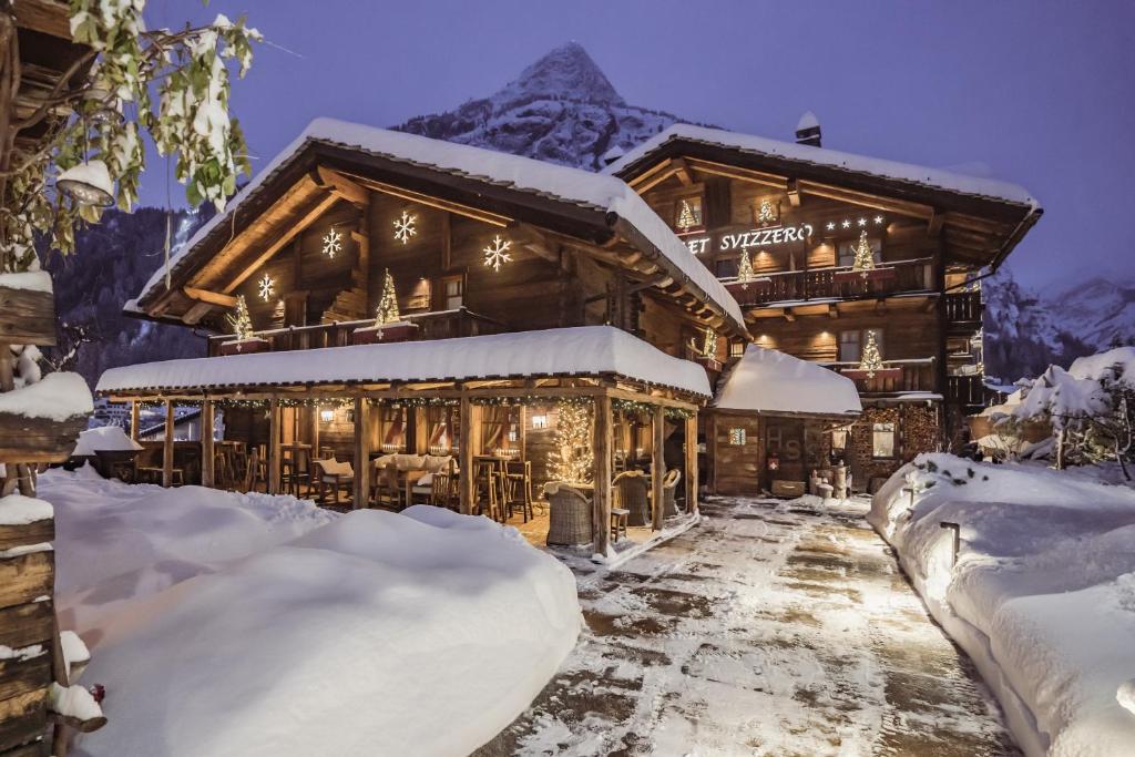 een blokhut in de sneeuw met bergen op de achtergrond bij Chalet-hotel Svizzero in Courmayeur