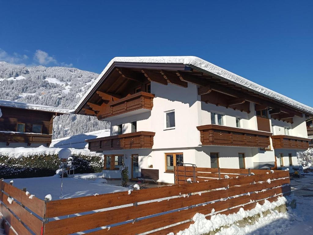 dom w śniegu z drewnianym płotem w obiekcie Appartement Kröll Katharina w mieście Zell am Ziller