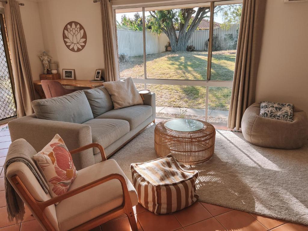 a living room with a couch and a chair at BEACH 400m, Big Yard, Playroom, Perfect for Families, Couples, Digital Nomads in Mandurah