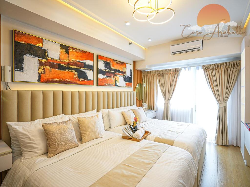 a bedroom with a large bed with white sheets at Casa Arabella - Wind Residences Tower 5 2018 in Tagaytay