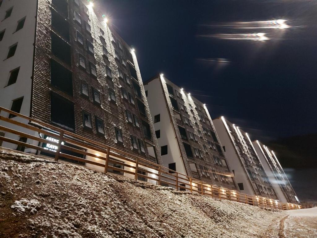 uma fila de edifícios altos à noite com luzes em Apartment Holiday Ravna Planina em Gornje Pale