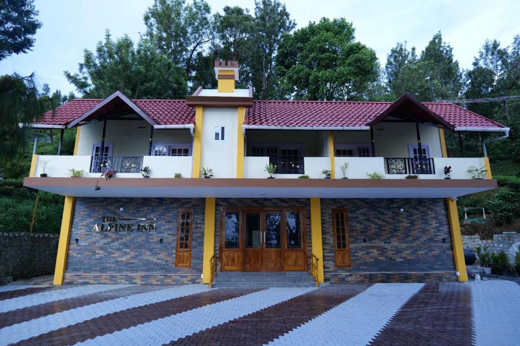 una casa con techo rojo en The Alpine Inn, en Gūdalūr