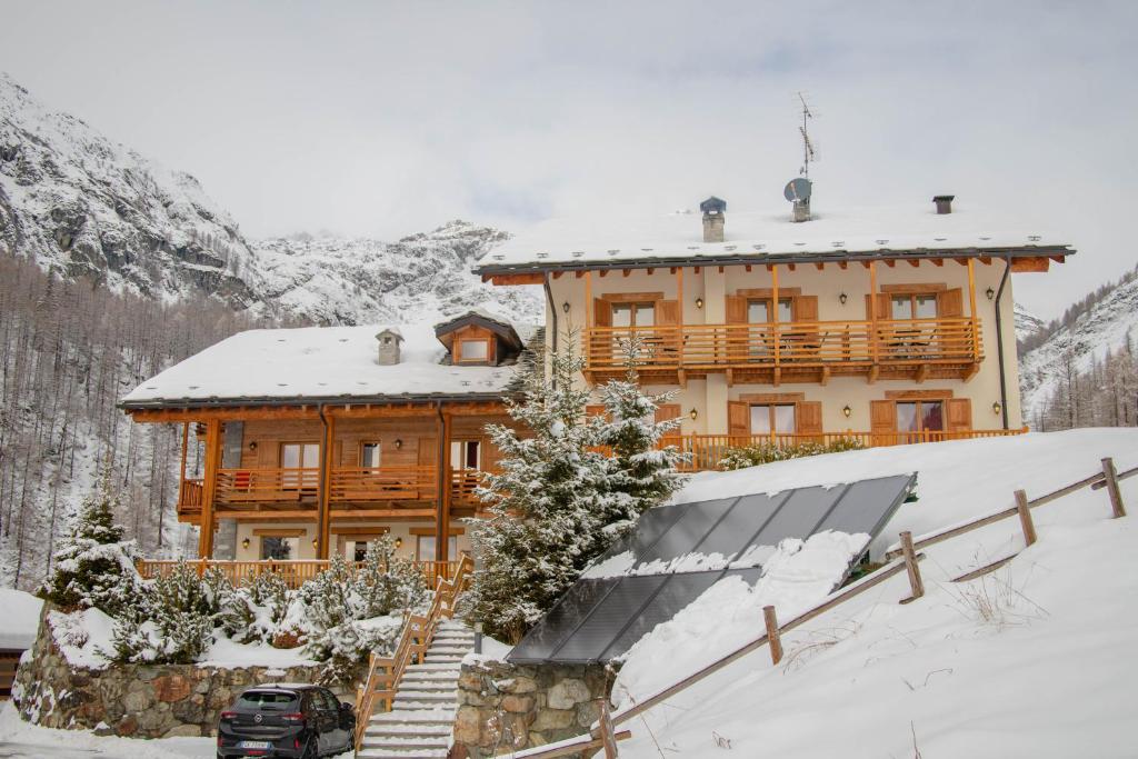 Casa de madera grande con techo cubierto de nieve en Ellex Eco Hotel, en Gressoney-la-Trinité