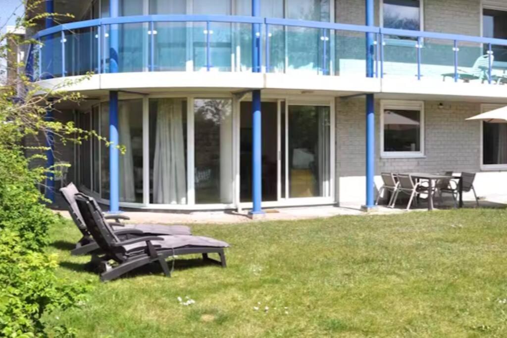 une maison avec une chaise et une table dans la cour dans l'établissement Appartement Badhotel 300, à Callantsoog