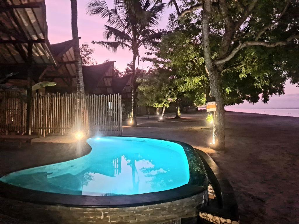 ein Schwimmbad in der Nacht mit einem Brunnen in der Unterkunft Beach House Penida in Nusa Penida