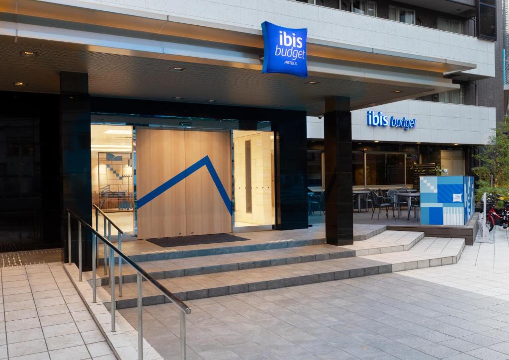 una tienda con un cartel azul en la parte delantera de un edificio en ibis Budget Osaka Umeda, en Osaka