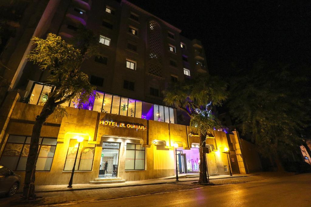 un edificio in una strada di notte con luci di El Oumara Hotel a Tunisi