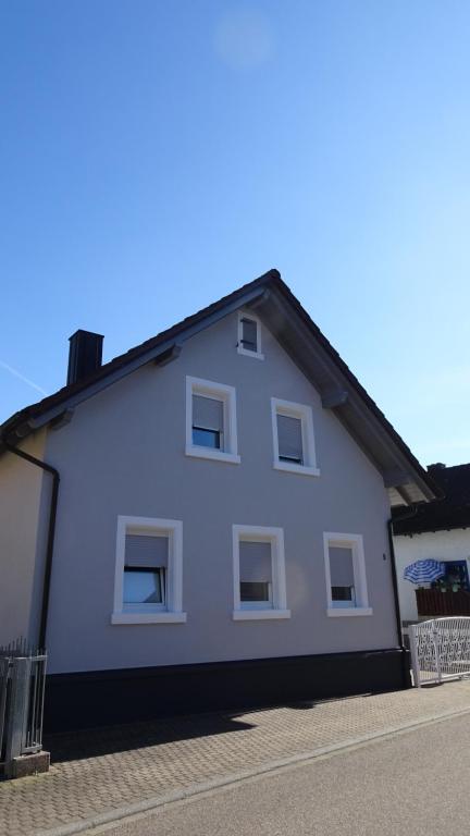 une maison blanche avec des fenêtres blanches sur une rue dans l'établissement Schwarz-Weiss, à Rust