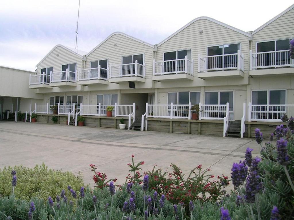 eine Reihe von Häusern mit Balkonen und Blumen in der Unterkunft A Great Ocean View Motel in Apollo Bay