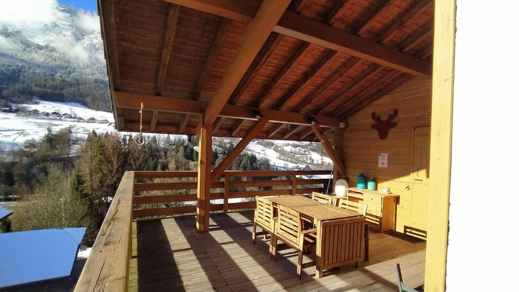 a porch of a cabin with a table and chairs at Chez Alphonse in Thônes