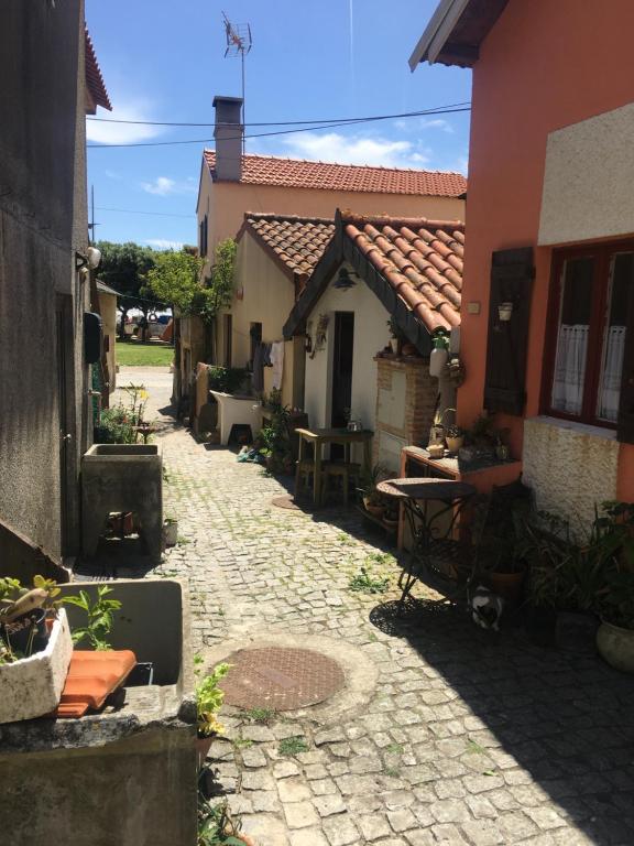 eine Gasse mit einem Haus, einem Tisch und Stühlen in der Unterkunft A Barraquinha 30 steps from sea in Apúlia