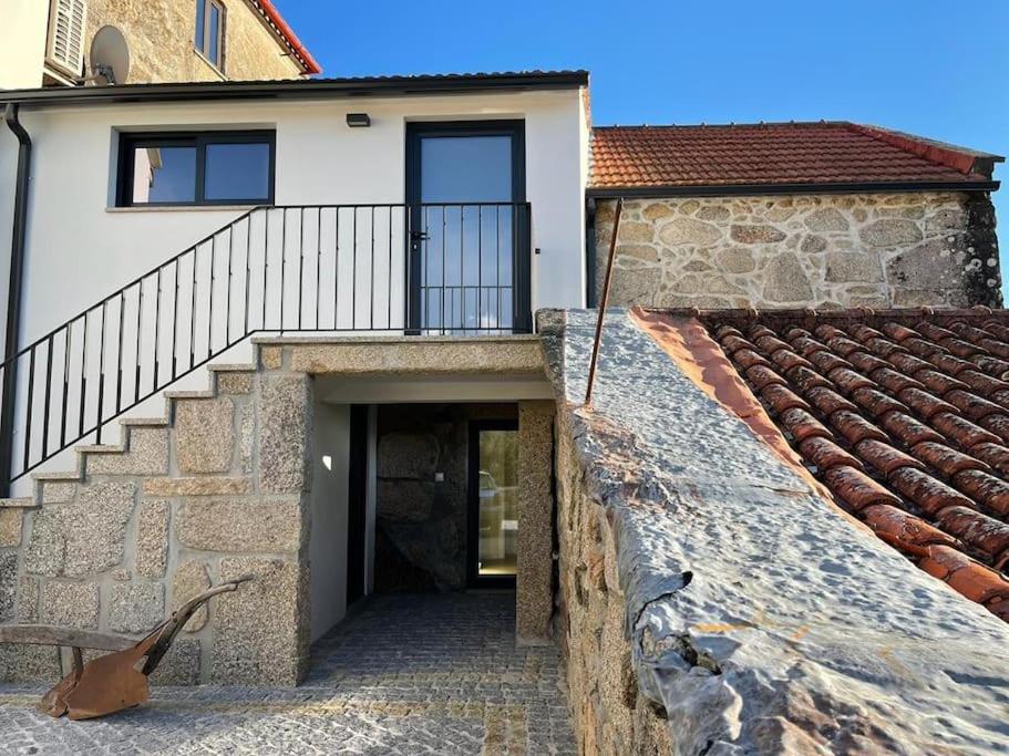 ein Haus mit einer Treppe, die zu einem Gebäude führt in der Unterkunft Casa dos Cortelhas in Arcos de Valdevez