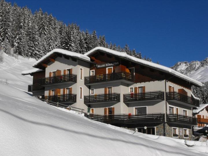 ein großes Gebäude mit Schnee an der Seite eines Berges in der Unterkunft Meublè Rosalpina in Valdidentro