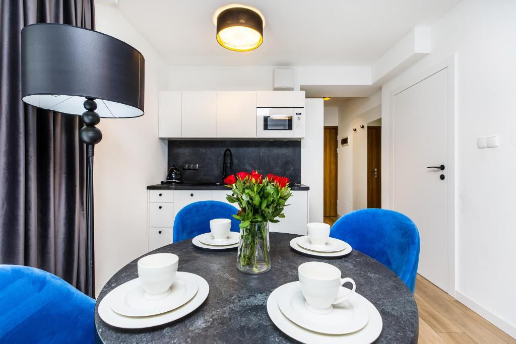 a dining room with a table and blue chairs at Grapa Ski - apartament Białka Tatrzańska in Białka Tatrzanska