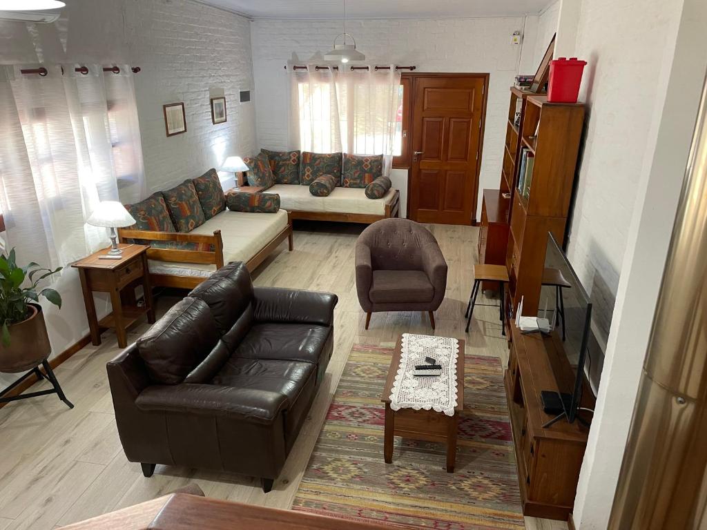 a living room with a black leather couch and a table at Magnolio in Colonia del Sacramento