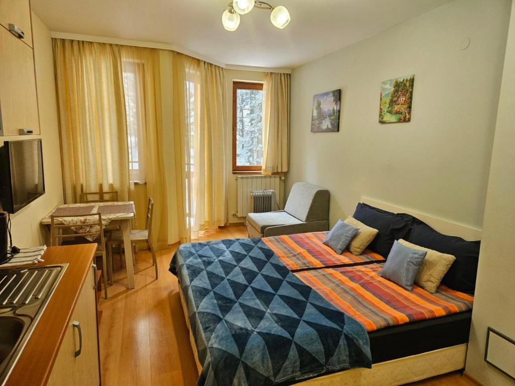 ein Schlafzimmer mit einem Bett und ein Wohnzimmer in der Unterkunft Borovets Villa Park studio in Borowez