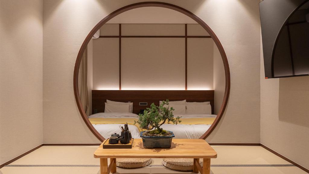 a mirror in a room with a bed and a table at Aank Ryokan Yosuriguri Hotel in Cheonan