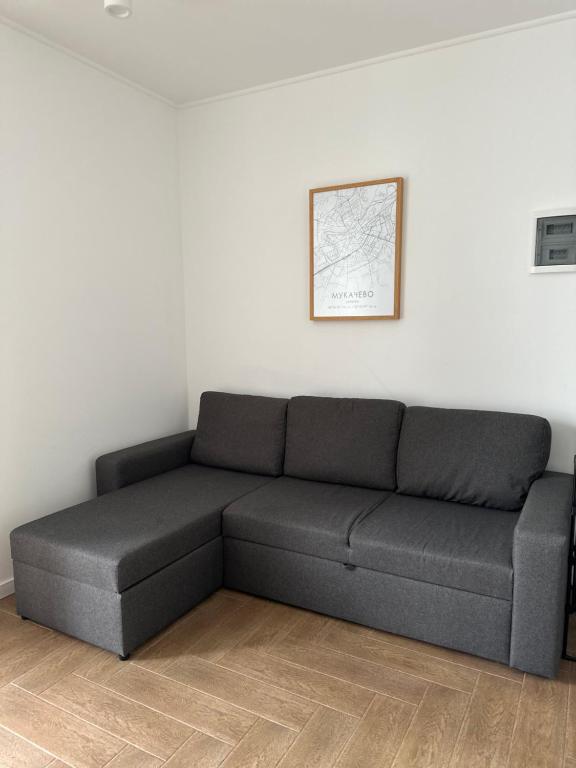 um sofá preto num quarto com uma parede branca em Modern apartament em Mukachevo