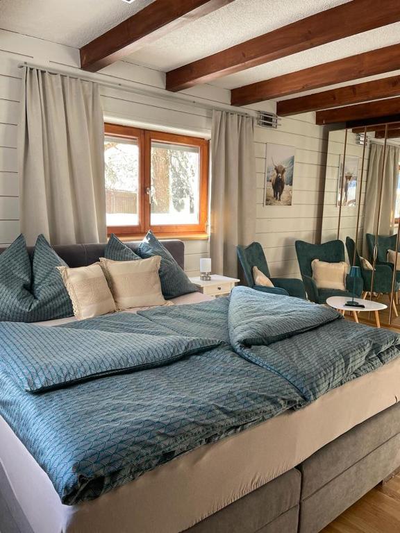 uma cama grande com um edredão azul num quarto em Ferienwohnung Jägerheim em Bürserberg