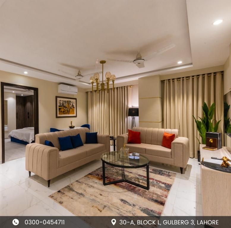 a living room with two couches and a table at The Opus Luxury Residences in Lahore