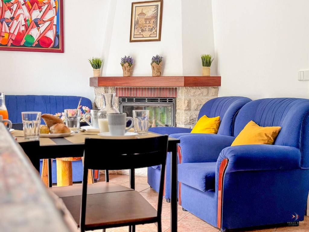 een woonkamer met blauwe stoelen en een tafel bij Pátio Privado com Churrasqueira by Férias em Figueira in Figueira da Foz