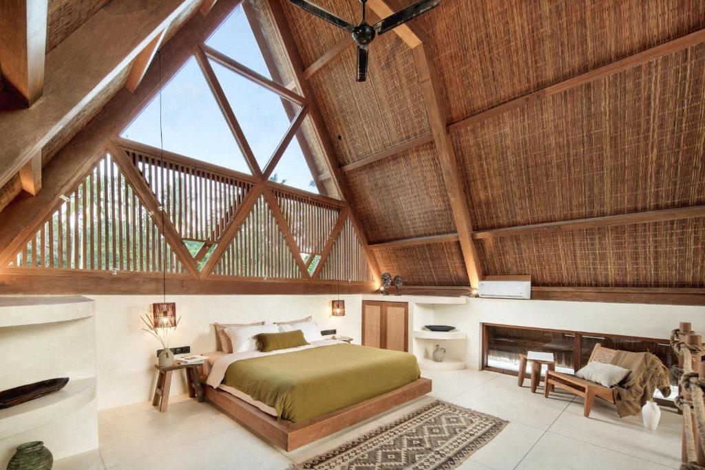 een slaapkamer met een bed en een gewelfd plafond bij Tias Villas in Kuta Lombok