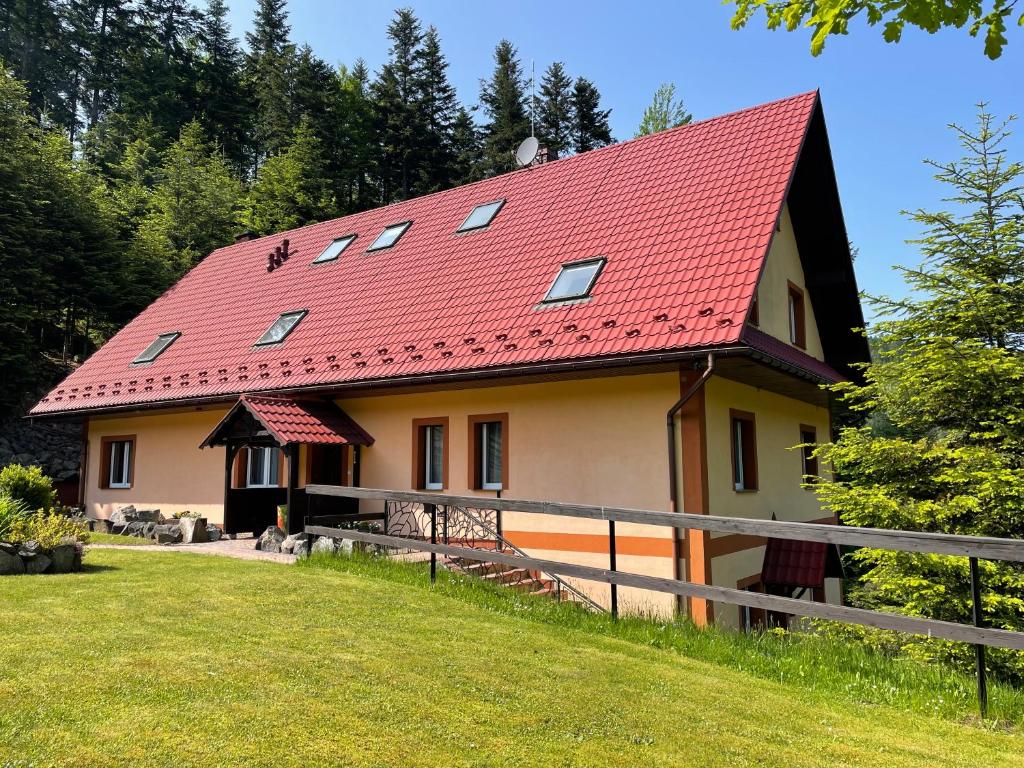 une maison avec un toit rouge sur une colline dans l'établissement Willa Arga, à Piwniczna-Zdrój