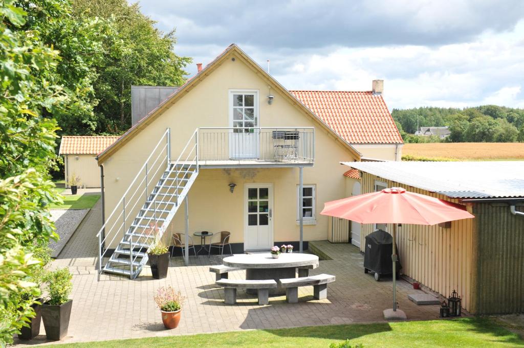 Herning Bed & Breakfast في هيرنينغ: منزل مع فناء مع طاولة ودرج