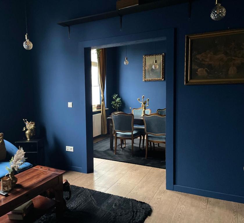 a living room with blue walls and a table at Blue Royal Apartment in Celle