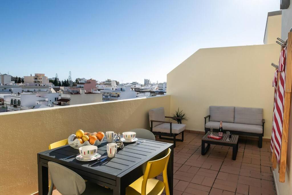 una mesa y sillas en un balcón con vistas en Penthouse Olhão with terrace, en Olhão