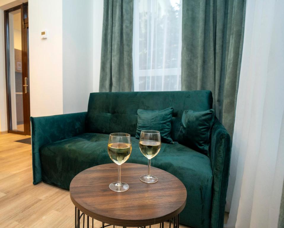 - deux verres de vin assis sur une table devant un canapé dans l'établissement Central Station Apartment No1, à Kaunas