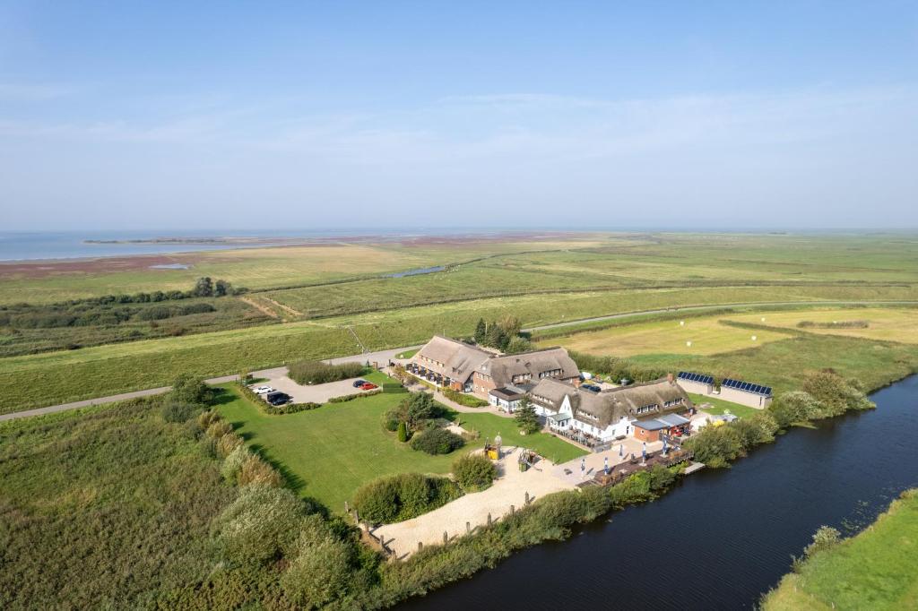 uma vista aérea de uma casa numa ilha num rio em Nordsee-Hotel Arlau-Schleuse em Husum