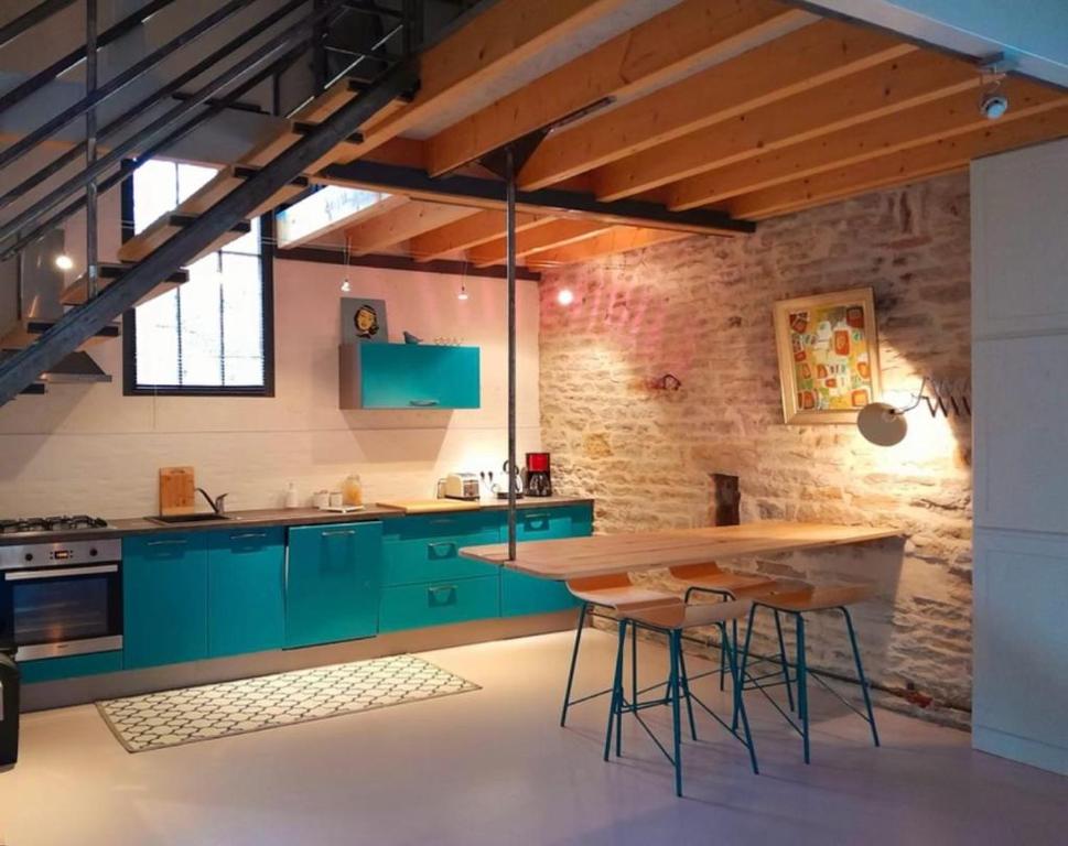 uma cozinha com armários verdes e uma mesa de madeira em Holiday Loft 58 em Arbois